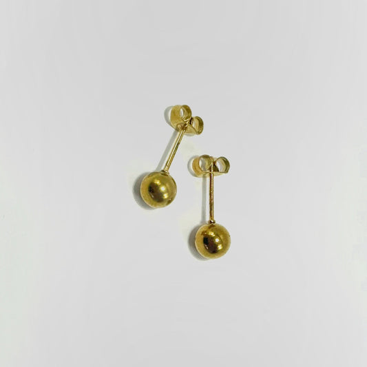 Pair of gold earrings on a light gray background